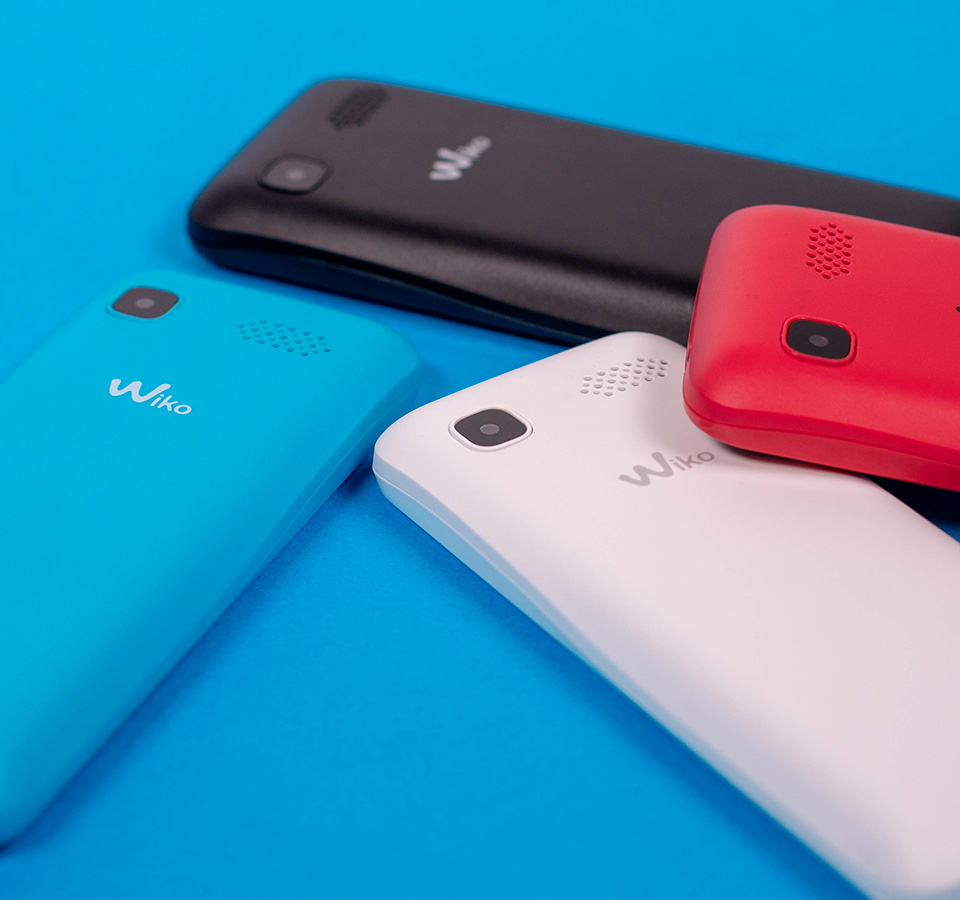 Vier kleuren van de Lubi5 Mobiles weergegeven op een blauwe achtergrond.